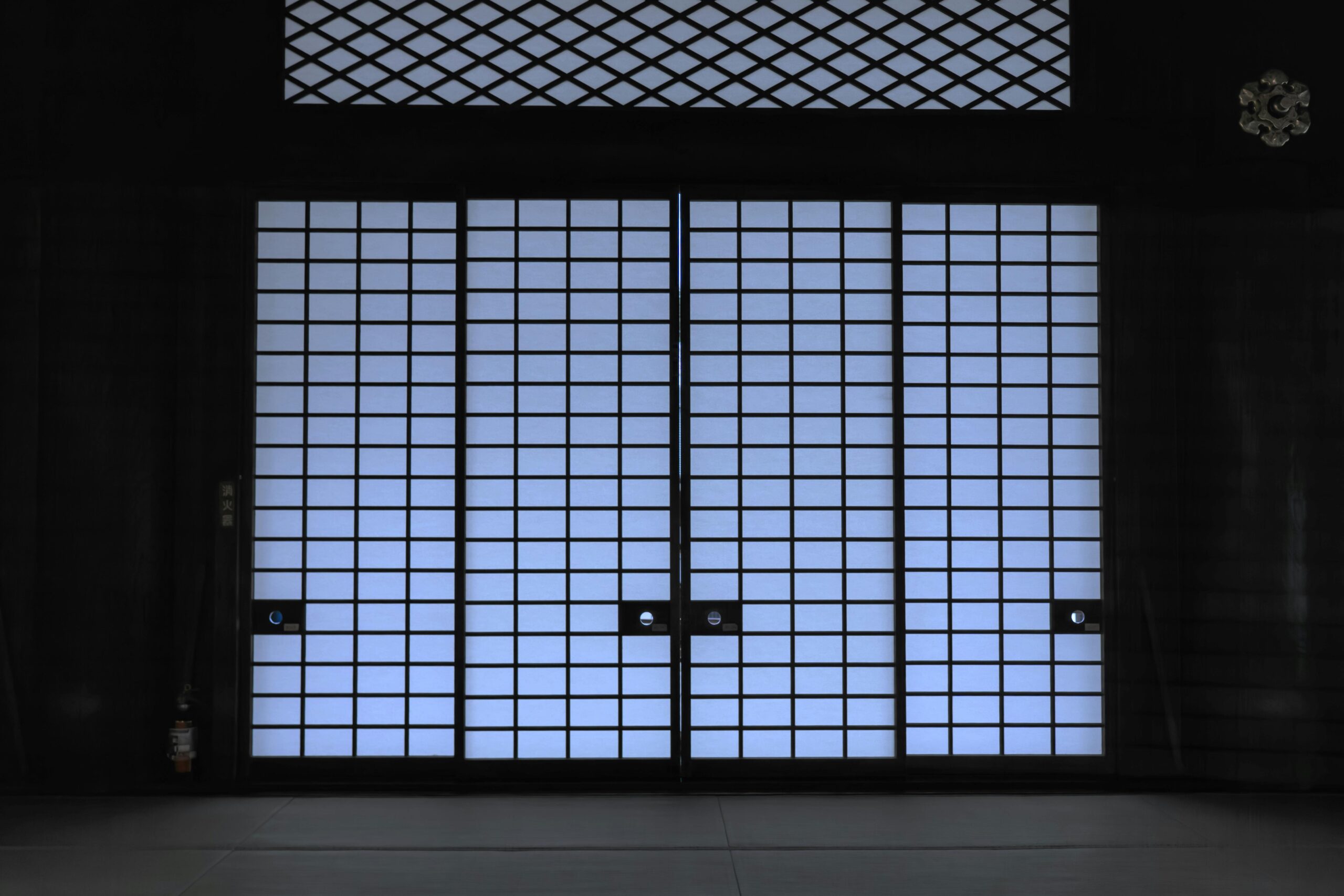 Elegant view of a traditional Japanese shoji door with soft lighting, creating a serene indoor atmosphere.